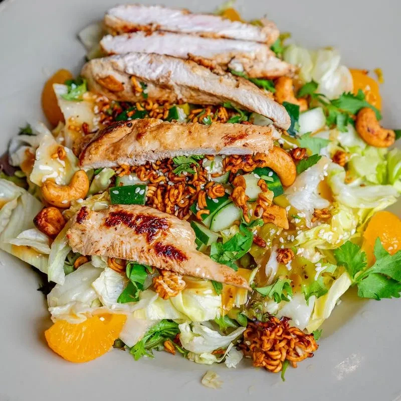 Chicken salad with grilled chicken, cashews, oranges, and crispy noodles.