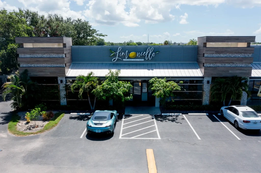 Aerial view of modern Limonecello restaurant exterior with cars and landscaping.