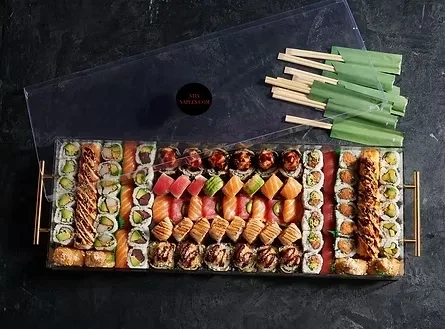 Rectangular platter of assorted sushi, sashimi, and rolls with chopsticks.
