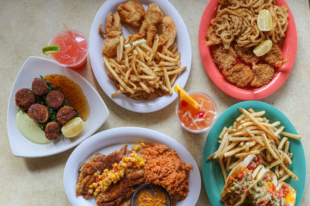 Diverse seafood spread with multiple dishes and colorful cocktails.
