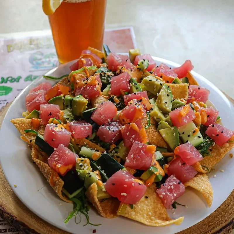 Poke nachos with raw tuna, avocado, cucumber, sauce, and sesame seeds.