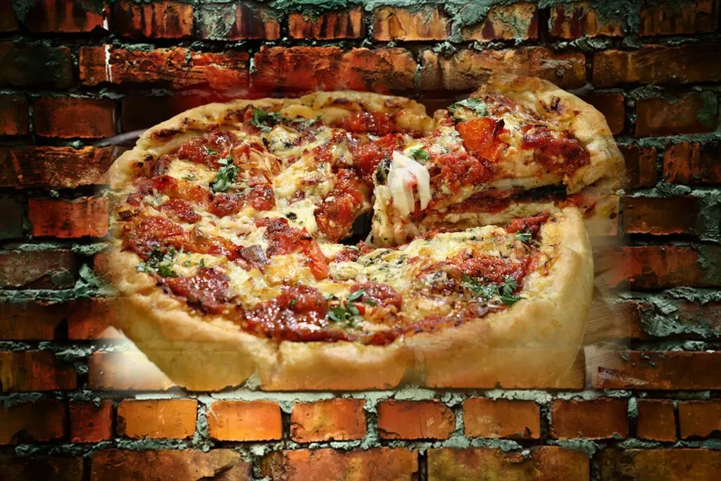 Deep-dish pizza slice with stretching cheese against a brick wall.