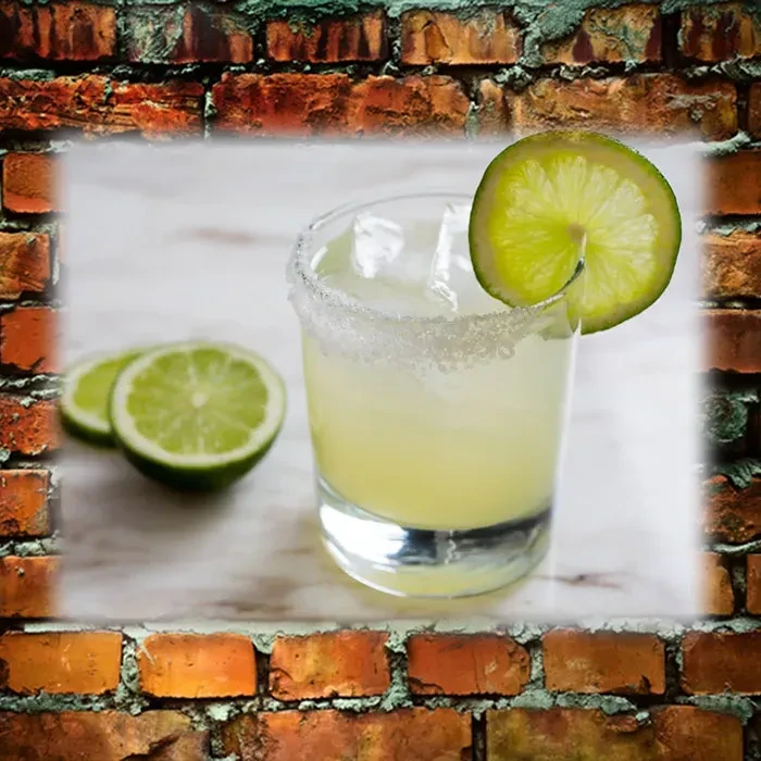 Margarita in glass with lime, ice, salted rim, brick background.