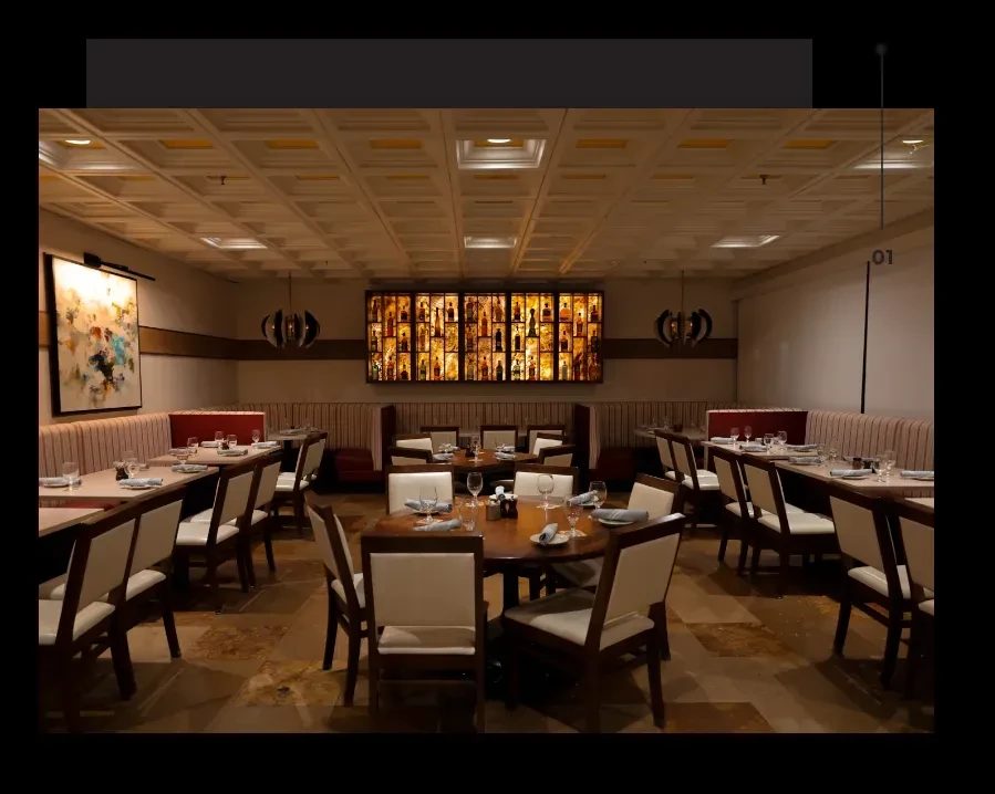 Empty, well-appointed restaurant dining room with set tables and glowing display.