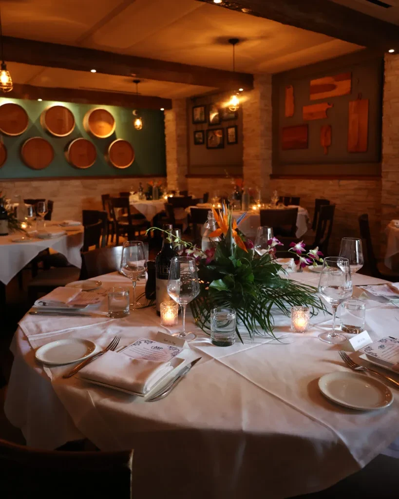 Meticulously set dining table with tropical flowers in a warm restaurant.