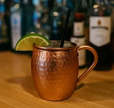 Close-up of a cocktail in a hammered copper mug with lime.