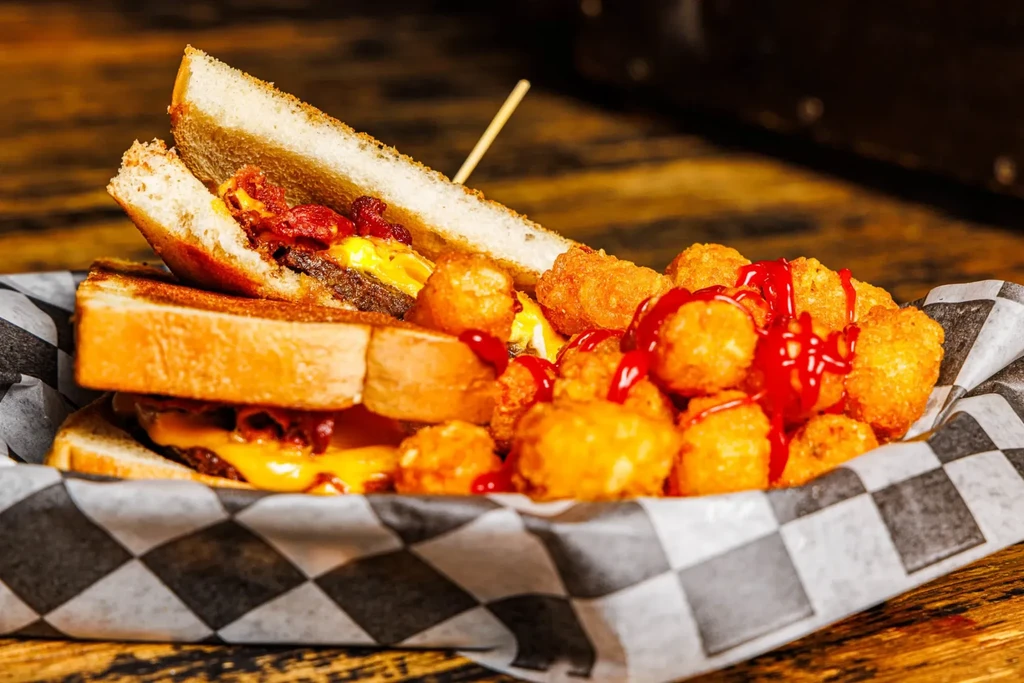 THOUGHTS:
The user wants an alt-text between 7 and 12 words.
It needs to be factual, concise, and descriptive, with no marketing language.
I need to focus on the key elements of the food presented.

Key elements:
- Sandwich (grilled cheese/patty melt with 