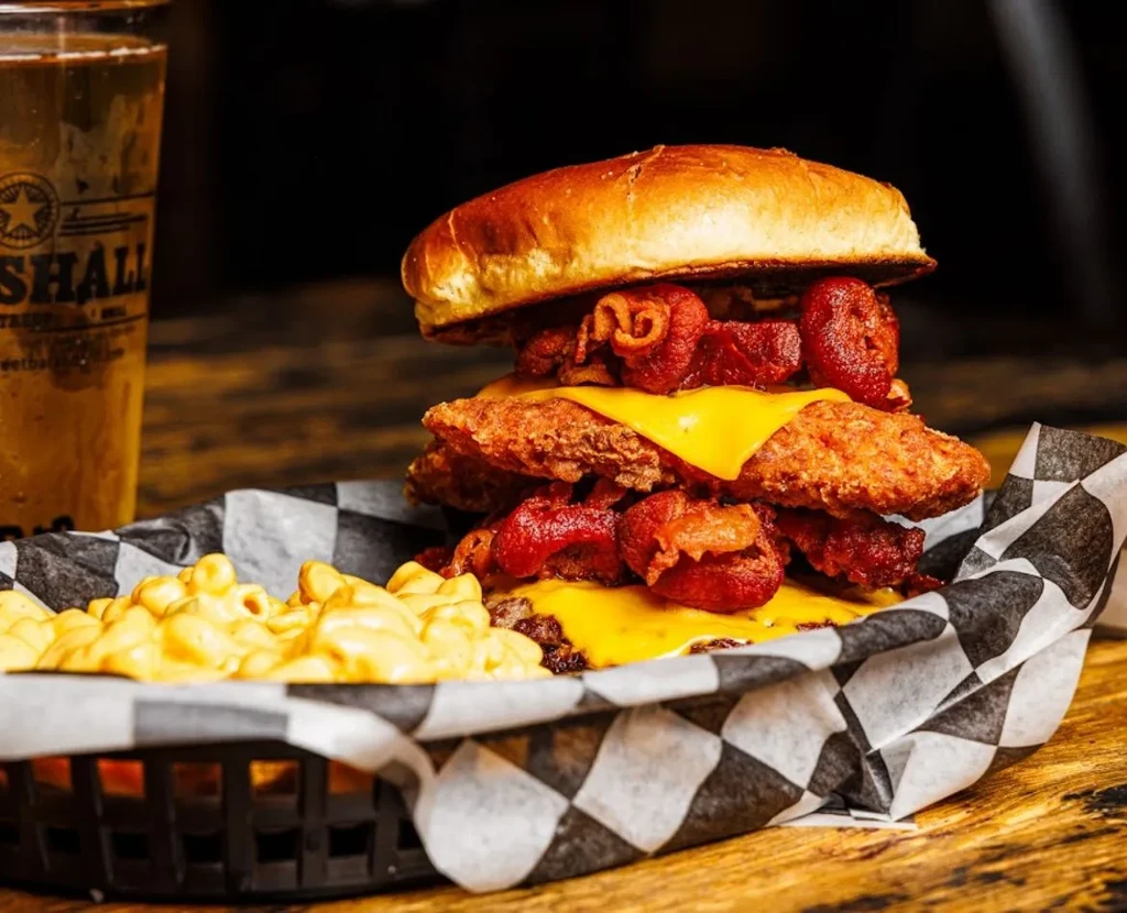Large fried chicken burger with bacon, cheese, and mac and cheese.