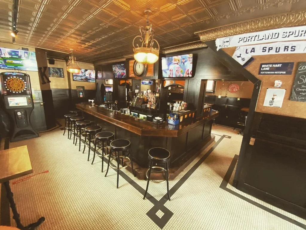 Empty rustic sports bar with ornate ceiling and Portland Spurs signs.
