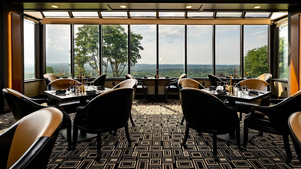 Elegant restaurant interior with panoramic green hill views, no people.