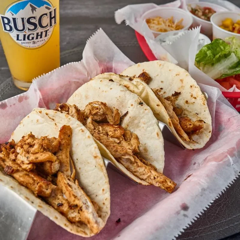 Three grilled chicken tacos and a Busch Light beer.
