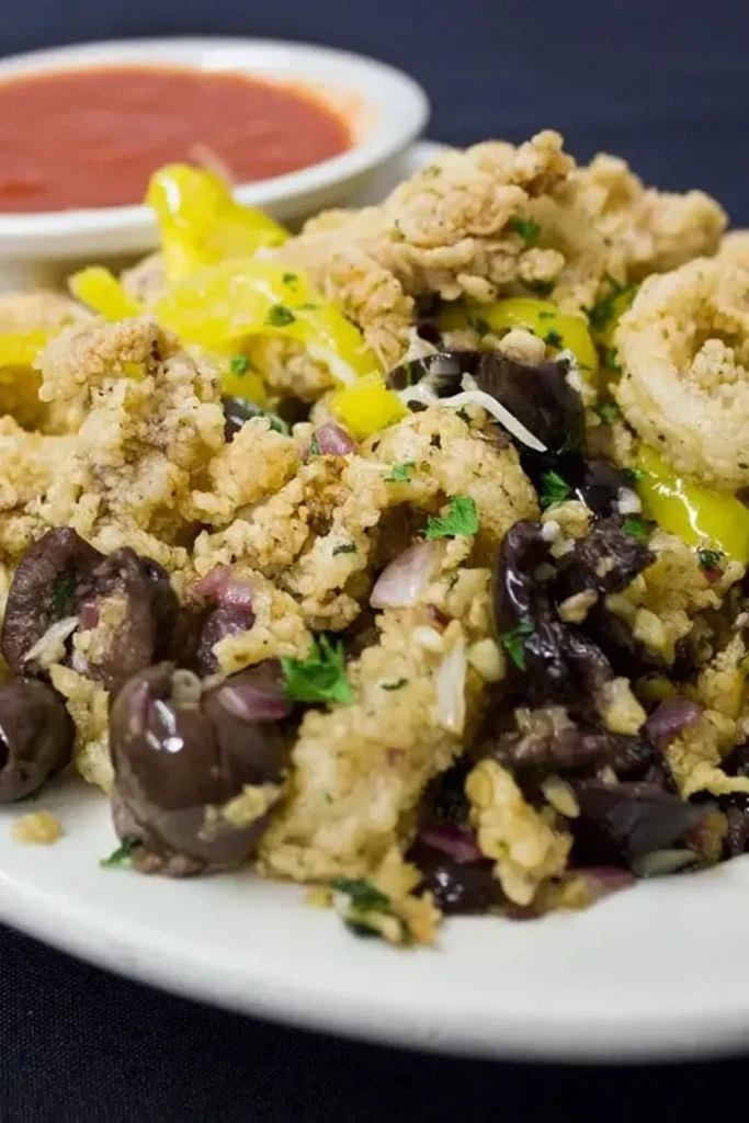 Fried seafood with olives, red onions, banana peppers, parsley, and dipping sauce.