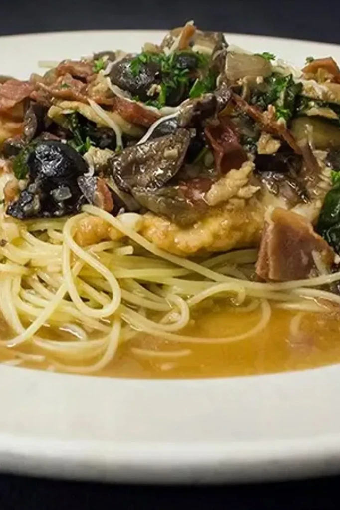 Top-down spaghetti with mushrooms, crispy prosciutto, and fresh herbs.