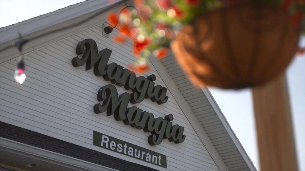Mangia Mangia Restaurant's white building exterior with prominent sign.