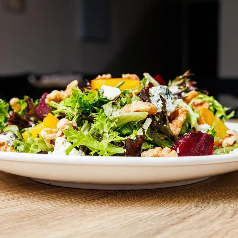 Mixed greens salad with roasted beets, crumbled blue cheese, and walnuts.