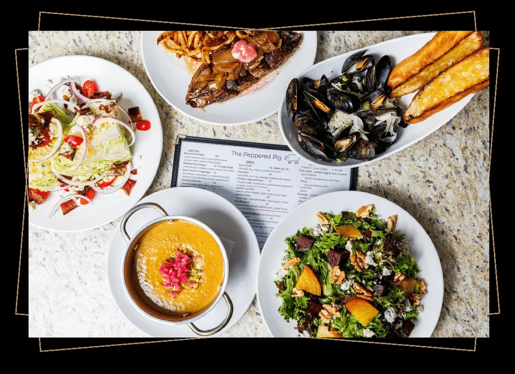 Overhead shot of a restaurant table with five diverse dishes and a menu.