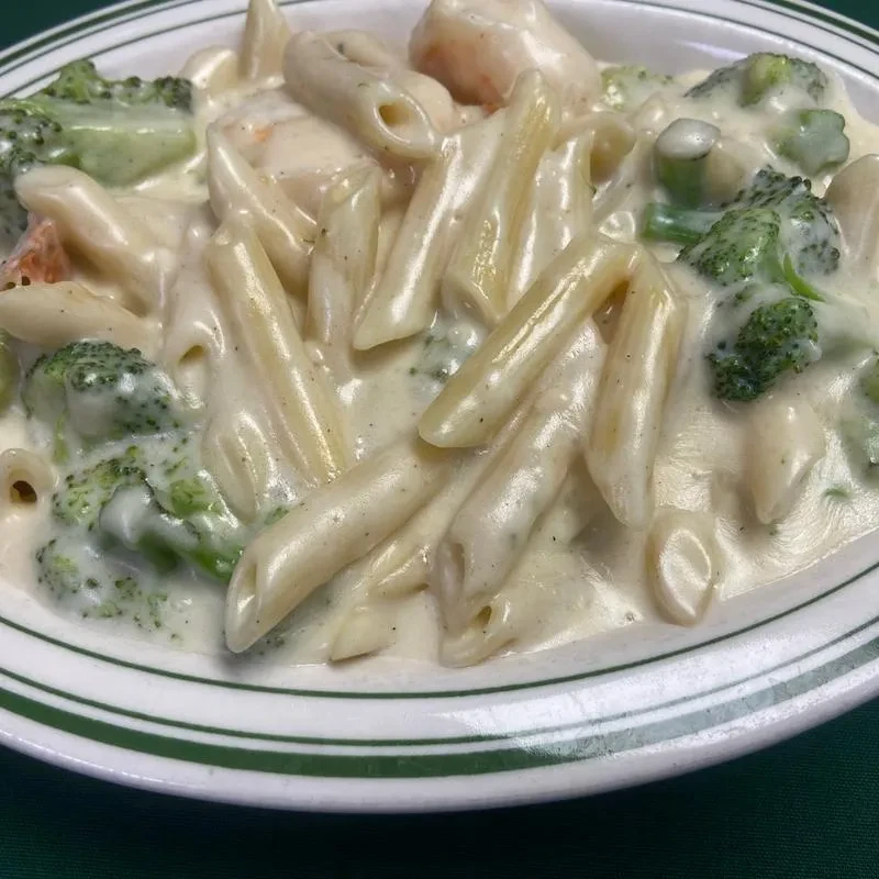 Penne pasta in creamy sauce with broccoli and seafood.