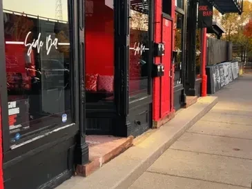 Side Bar exterior with black window frames and visible red interior.