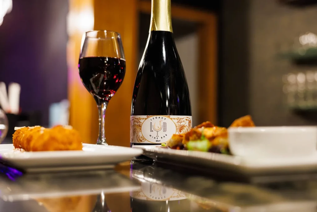 Wine bar setting with red wine, brut, and appetizers.