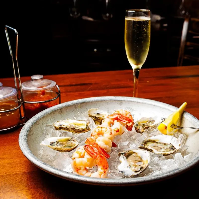 Oysters, shrimp, lemon on ice with sauces and champagne.