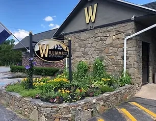 Rustic stone Williams Restaurant building with landscaped garden and prominent sign.