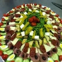 A circular platter displaying a colorful antipasto selection.