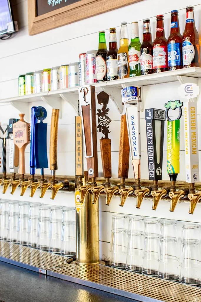 Bar counter with golden beer taps, bottled beers, and canned beverages.