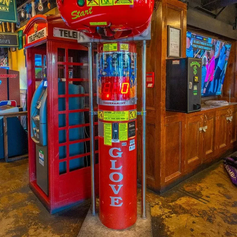 Red arcade punching game, red phone booth with ATM, change machine.