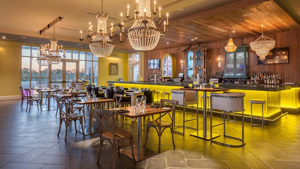 Beautifully decorated, empty restaurant and bar area with warm lighting.