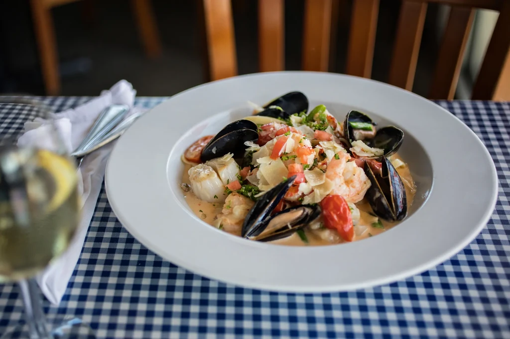 Seafood pasta with mussels, shrimp, scallops, Parmesan, and creamy sauce.