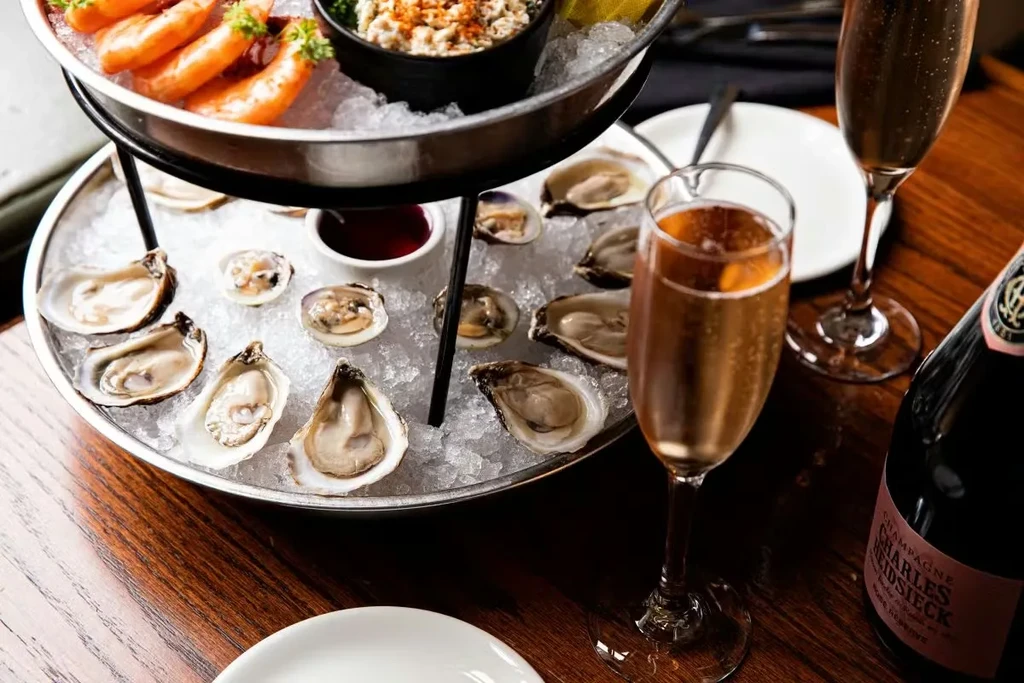 Two-tiered seafood tower with oysters, shrimp, and Charles Heidsieck champagne.
