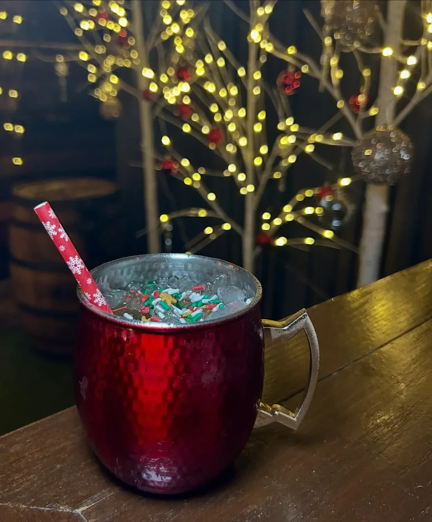 Hammered red copper mug with festive drink, sprinkles, and snowflake straw.