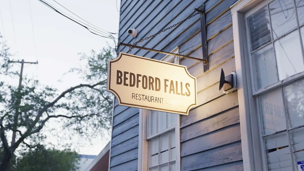 Ornate Bedford Falls Restaurant & Pub sign on building exterior.
