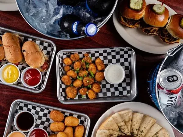 Overhead shot of casual food and drinks on a dark wooden table.