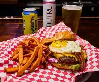 Burger with egg, bacon, sweet potato fries, Twisted Tea, NÜTRL, beer.