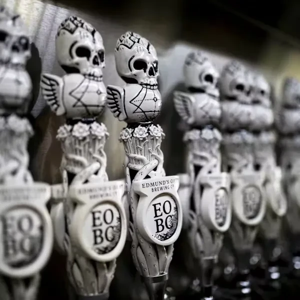 Greyscale Edmund's Oast beer tap handles featuring skulls and wings.