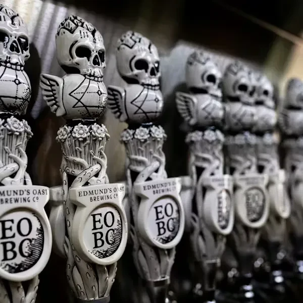 Row of distinct skull-topped Edmund's Oast beer tap handles.