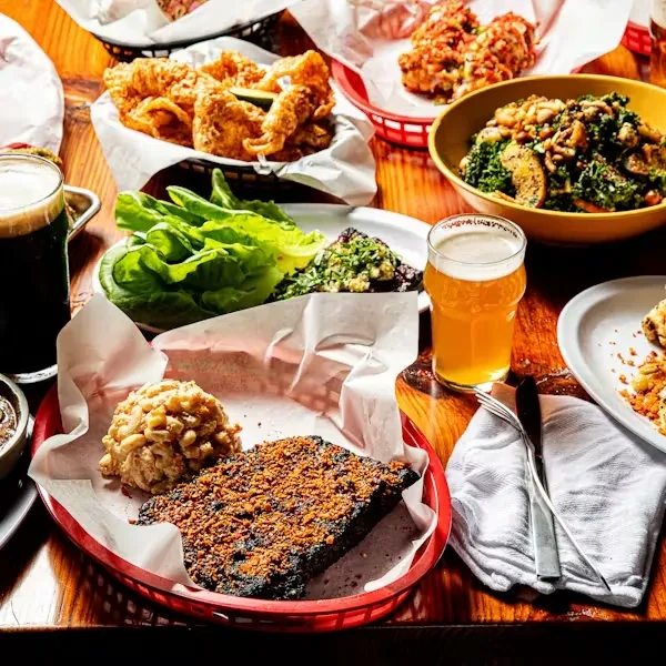 Overhead view of a wooden table laden with diverse food and drinks.