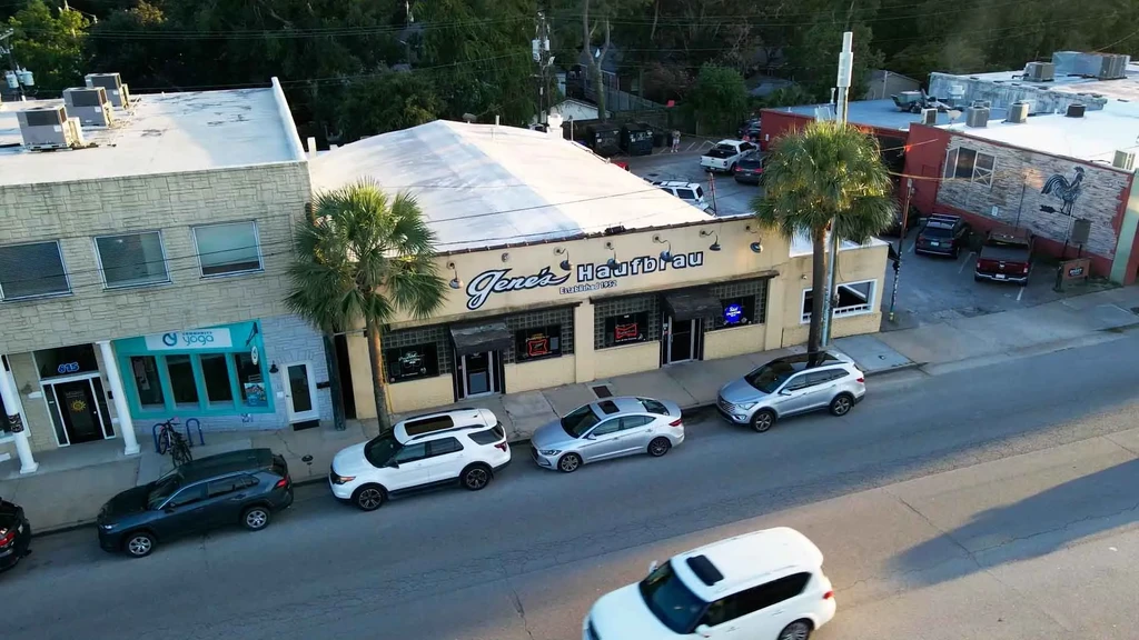 High-angle aerial of Gene's Haufbrau, Community Yoga, and parked cars.