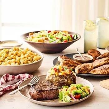 A comprehensive spread of steak, chicken, potato, macaroni, and salads.