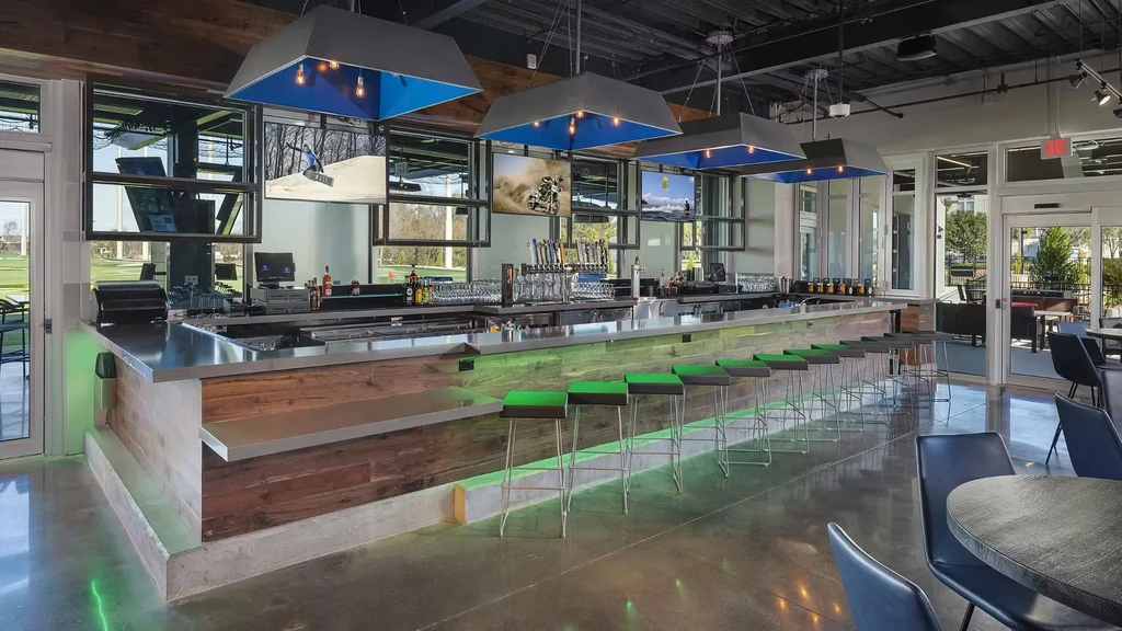 Modern sports bar interior with illuminated counter, TVs, and taps.