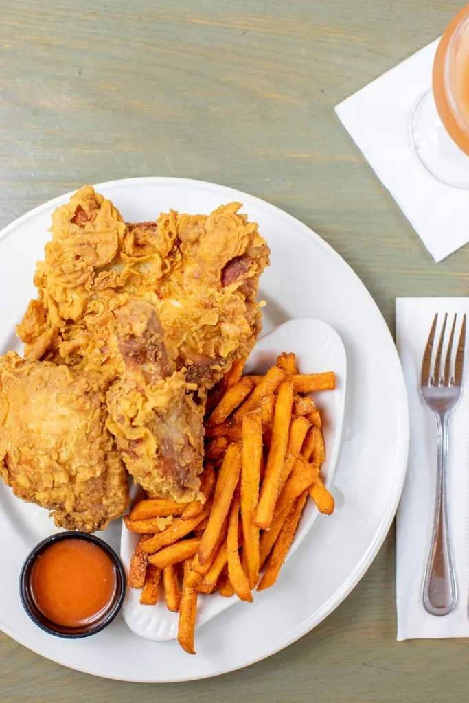 Overhead view: crispy fried chicken, sweet potato fries, dipping sauce.