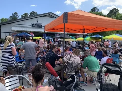 Tanner's Kitchen: Crowded outdoor patio with colorful umbrellas and canopies.