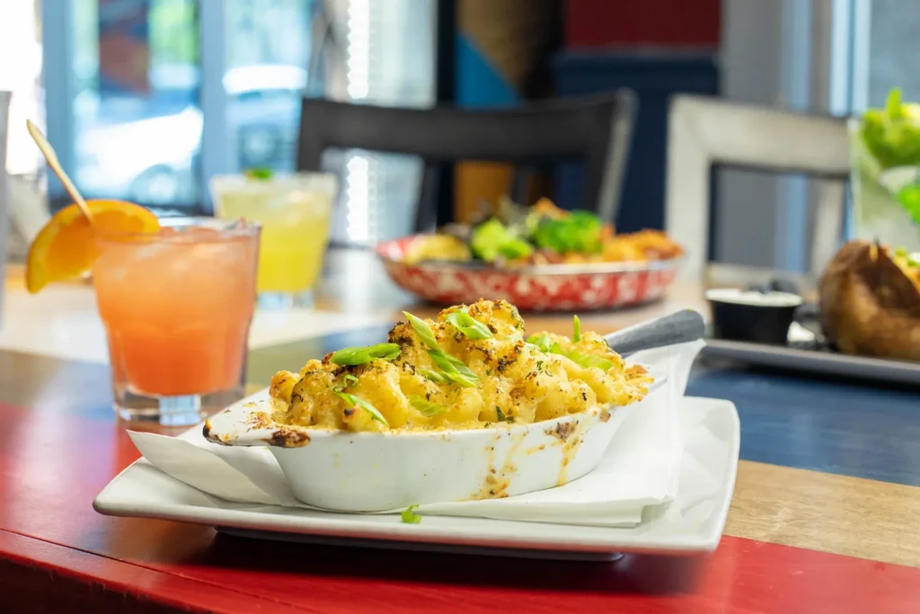 Golden-brown baked pasta dish with green onions, on a white plate.