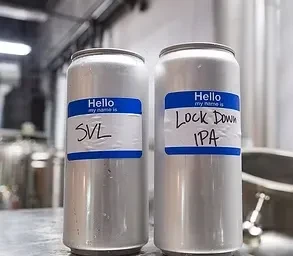 Two cold silver cans with 'SVL' and 'Lock Down IPA' name tags.