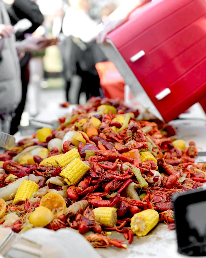 Large pile of crawfish, corn, and lemons being poured.
