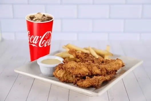 Crispy fried chicken tenders, french fries, dipping sauce, Coca-Cola.