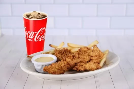 Golden-brown chicken tenders, french fries, dipping sauce, and Coca-Cola.