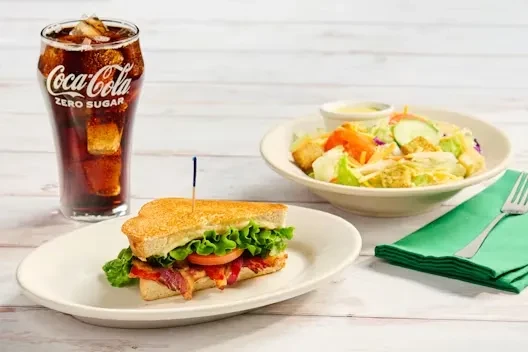 Complete meal with BLT sandwich, side salad, and Coca-Cola Zero Sugar.