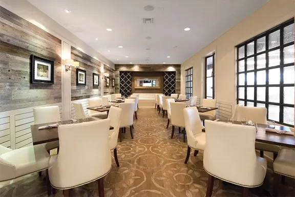 Elegant, empty restaurant dining room featuring set tables and sophisticated decor.